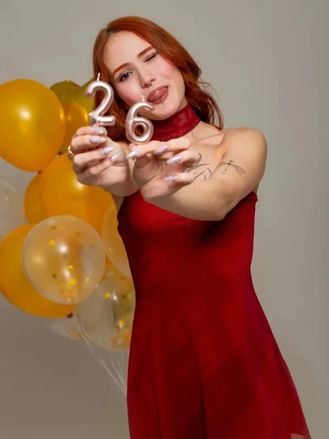 Mujer con vestido rojo sosteniendo un número dorado