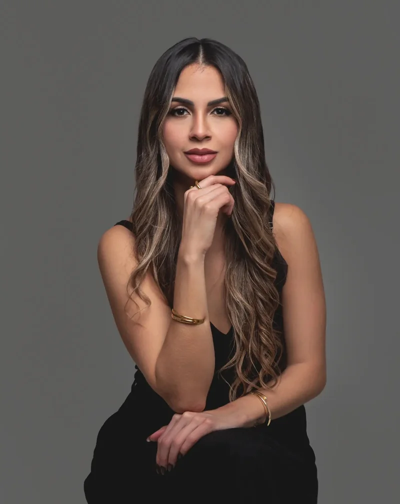 Retrato de mujer con vestido negro y mano en el mentón